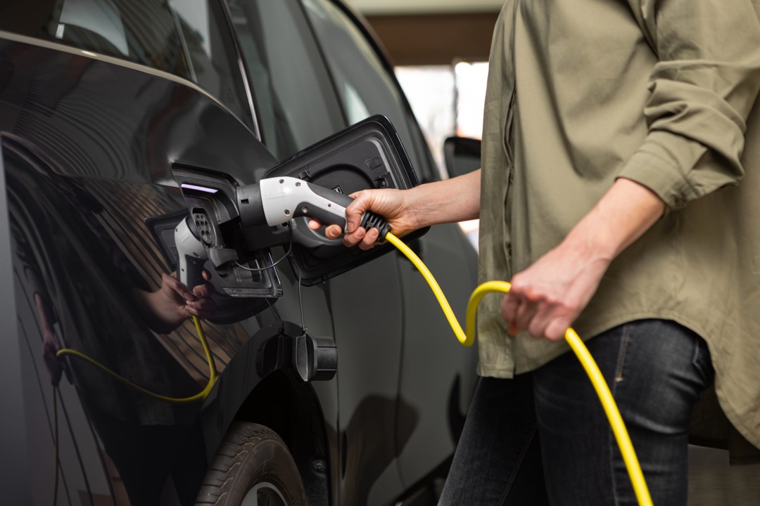 woman charging black EV